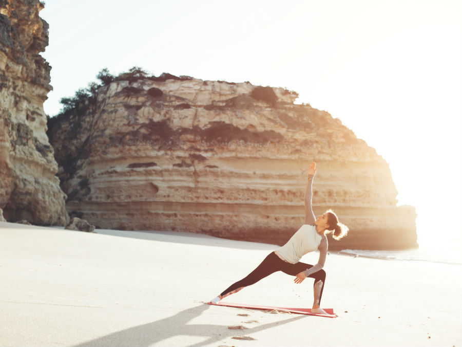 Woman doing yoga on the beach